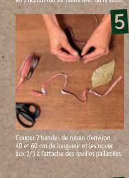couper 2 bandes de ruban d'environ 40 et 60 cm de longueur et les nouer aux 2/3 à l'attache des feuilles pailletées